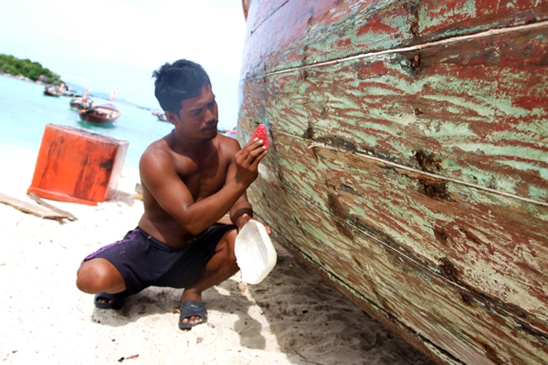 7. A sea gypsy fixes his boat on Lipe Island in the Tarutao marine national park. Sea gyysy rely on fishery which could be destroyed by mega project
